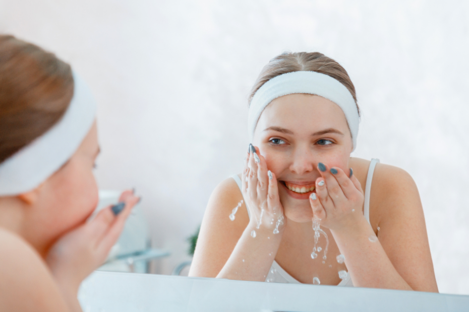 Woman cleansing her face at sink