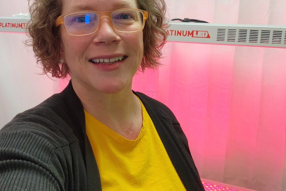 Windy Linde, owner, licensed esthetician, and licensed massage therapist at Linde Esthetics & Wellness Studio, smiling inside the studio on a workday.